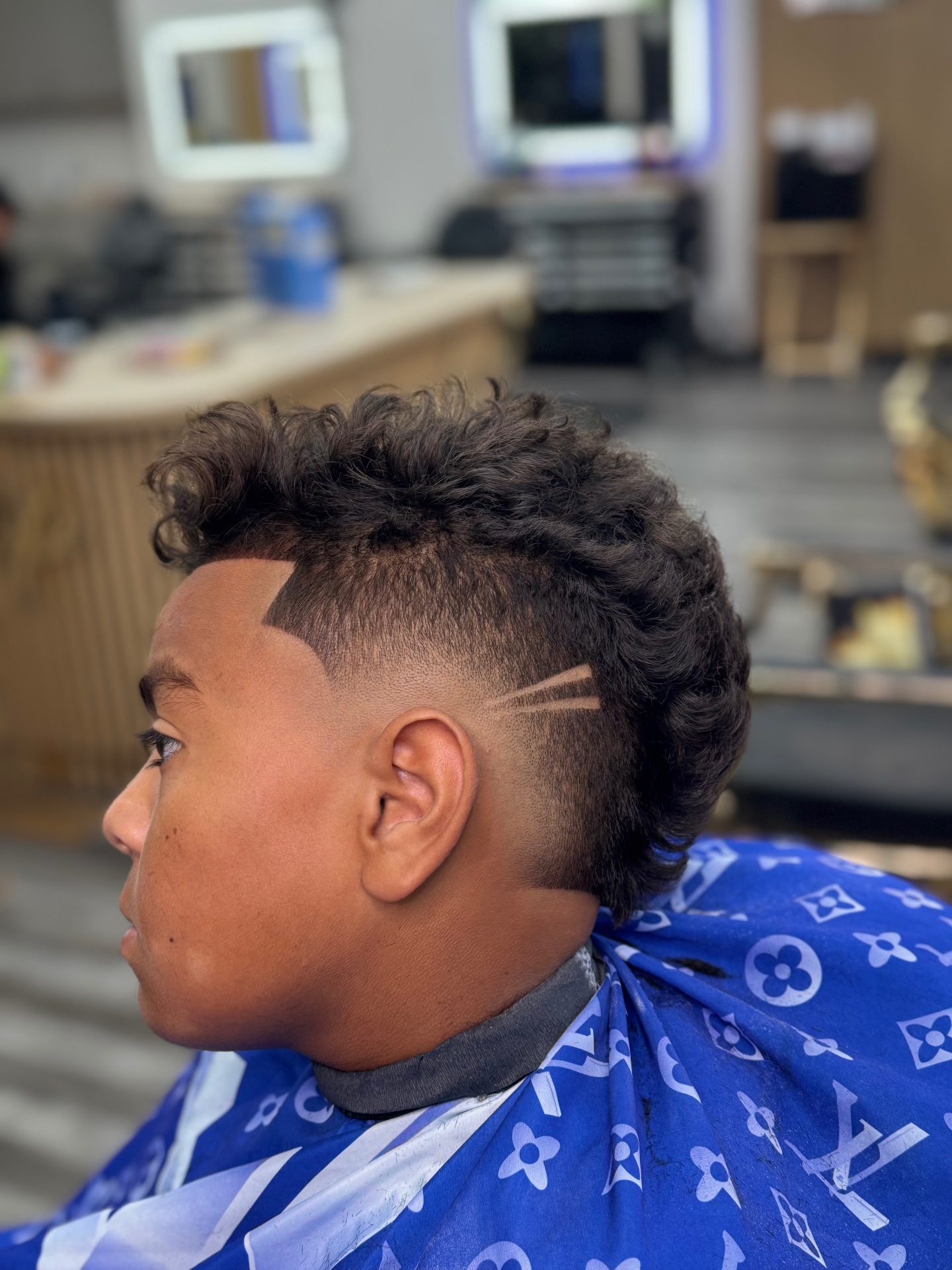 Clean fade with a detailed line design and curly top